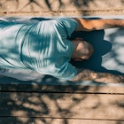 A man in child's pose on a yoga mat.