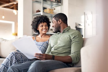Husband and wife sitting on couch looking happy together