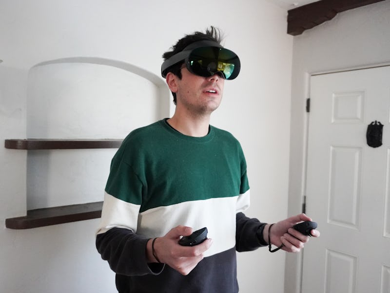 Inverse associate editor Ian Carlos Campbell wearing the Oculus Quest Pro VR headset and using the h...