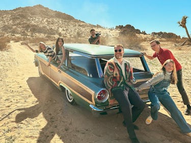 Michelle Williams wearing a black & white strip sweater. Seth Rogan wears a colorful cardigan sweate...