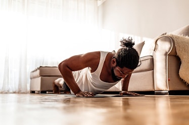 A man doing push-ups in his living room.