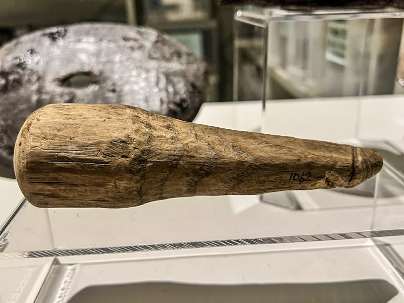 A wooden, penis-shaped object on display 