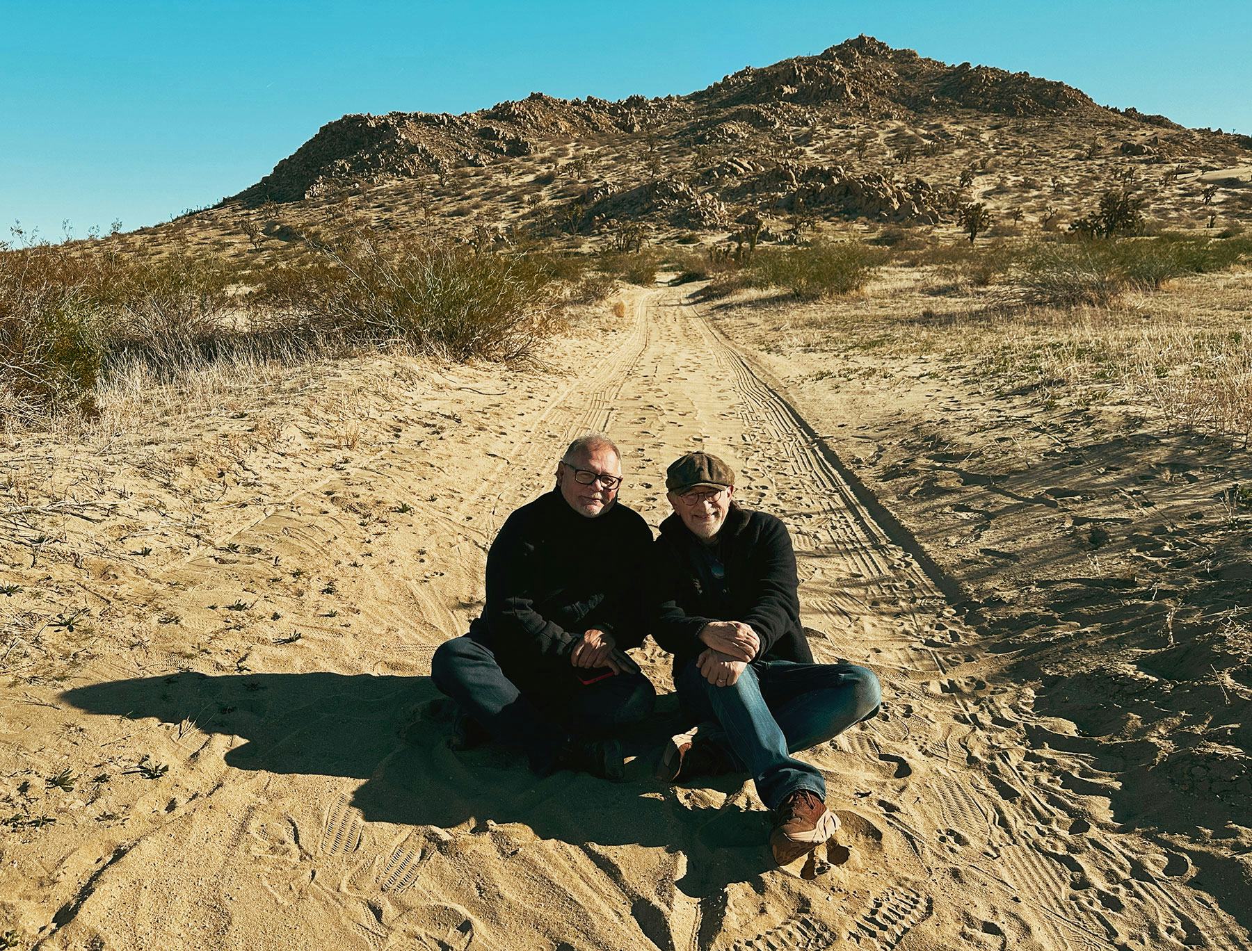 Director Steven Spielberg (right) with Director of Photography Janusz Kaminski sitting on a hill in ...