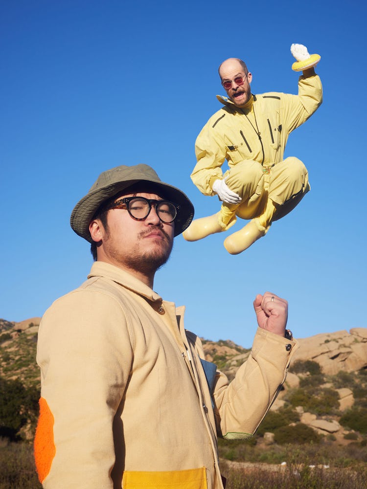 a man jumping behind a man posing