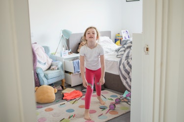A girl in her messy bedroom, throwing a tantrum.