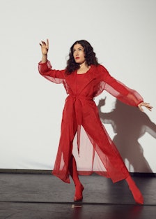 Kate Berlant wears Herno coat, stylist's own bodysuit, Manolo Blahnik shoes, Falke tights