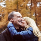 Young woman kissing older father on the cheek