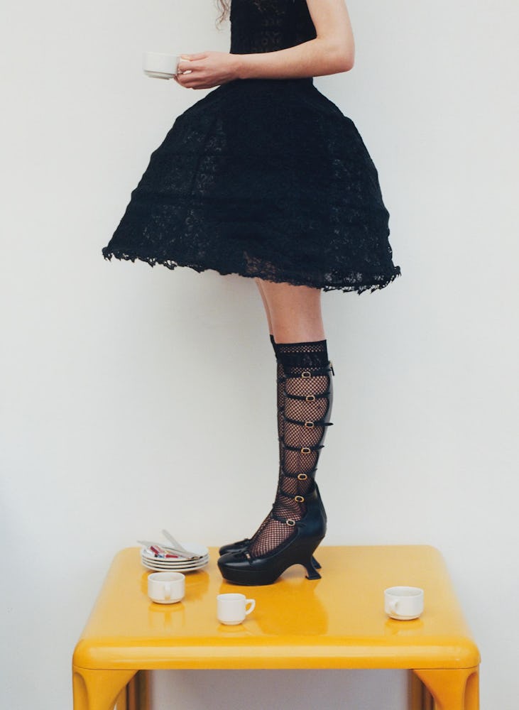Model wearing a black gown, black laced socks and shoes