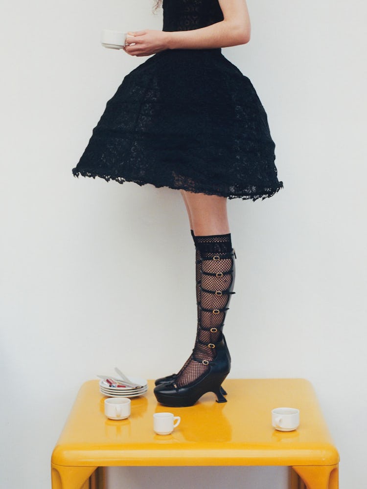 Model wearing a black gown, black laced socks and shoes