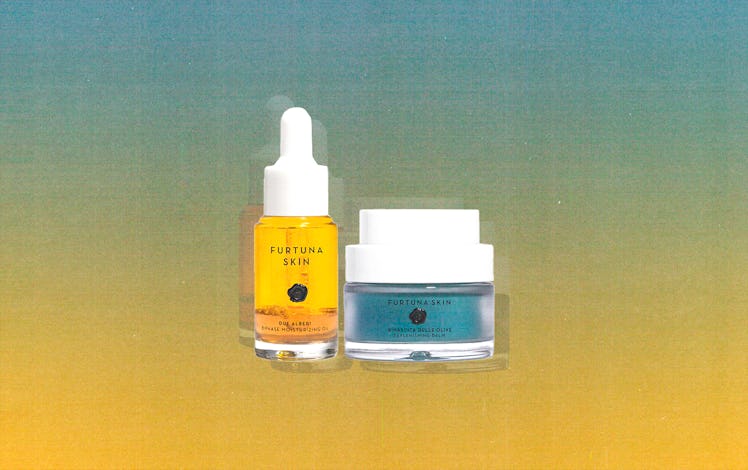 a vial of golden face oil and a jar of blue face balm, both from the brand Furtuna skincare, against...