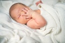 打嗝的婴儿用手捂着嘴。