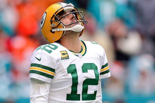 Aaron Rodgers #12 of the Green Bay Packers reacts after a play against the Miami Dolphins during the...