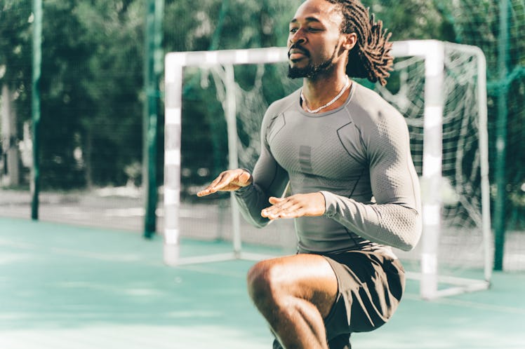 A man outside doing knee highs exercise.