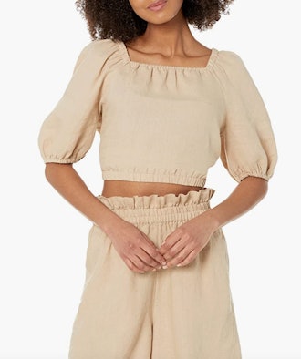This 100% linen top features a square neck, bloused three-quarter sleeves, and a cropped length