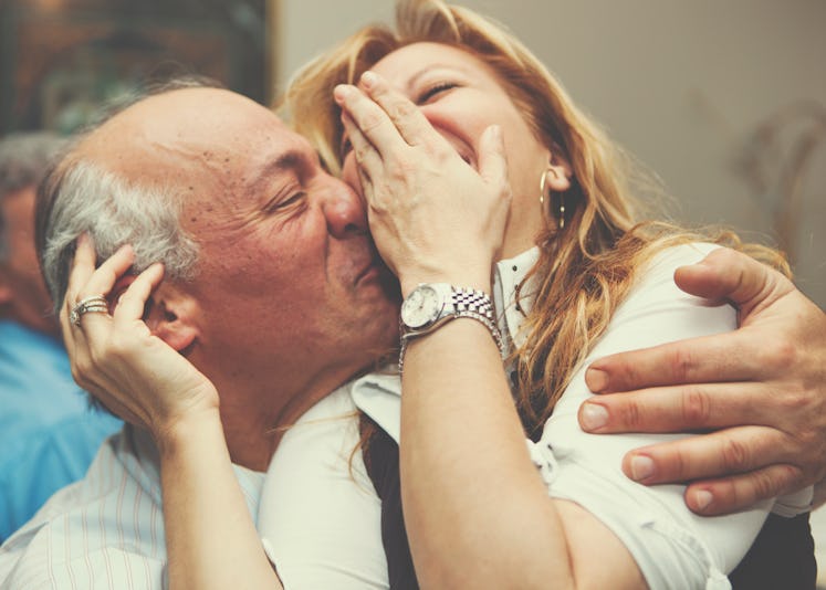 Older man and woman laughing and hugging one another