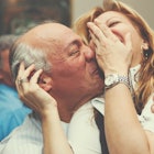 Older man and woman laughing and hugging one another