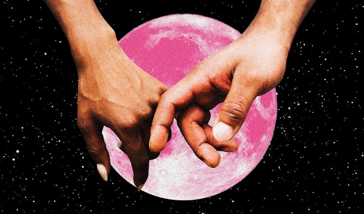 A couple holding hands in front of a pink moon after reading their 2023 Valentine's Day horoscope.