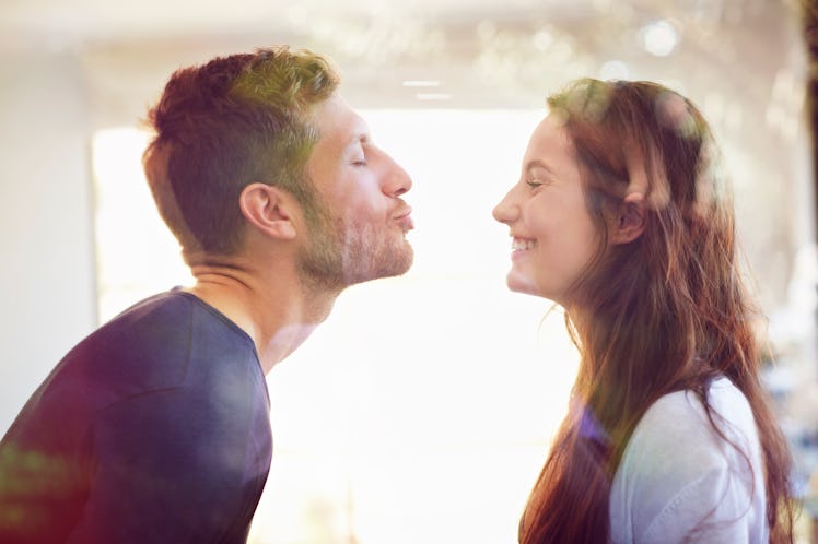 Happy couple laughing while preparing to kiss one another