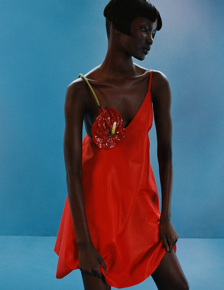 Model Abény Nhial wears orange silk dress.