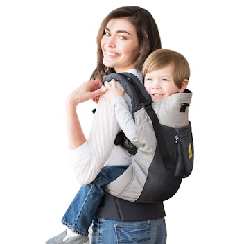woman holding child in backpack carrier