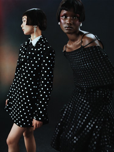 Model Chen wears a black & white polka dot jacket and earrings. 
