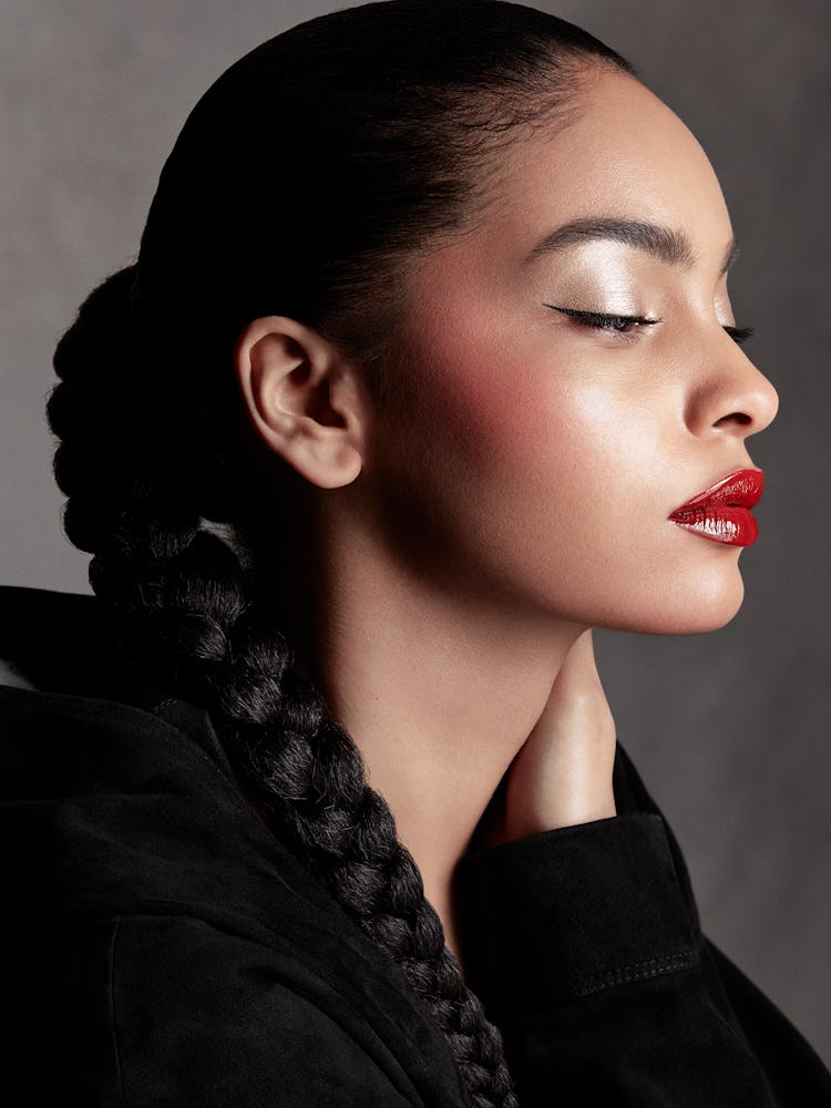 Model Sharon Aléxie wears a black bodysuit and red lipstick.
