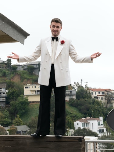 Paul standing on a fence in his suit
