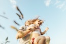 A dad picks up his daughter spins her, outside in nature.