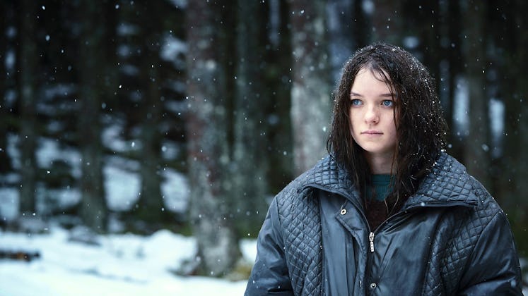 The titular character from Hanna (2019) stands in a snowy forest.