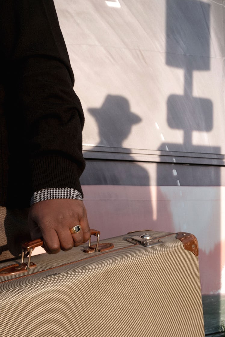 a person's hand holding a suitcase
