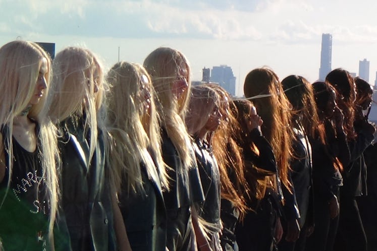 a line of people wearing blonde, red, and brown wigs with long hair