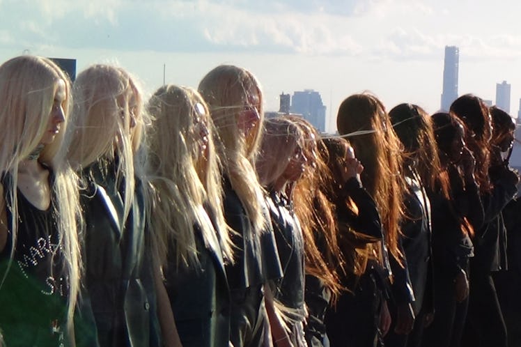 a line of people wearing blonde, red, and brown wigs with long hair
