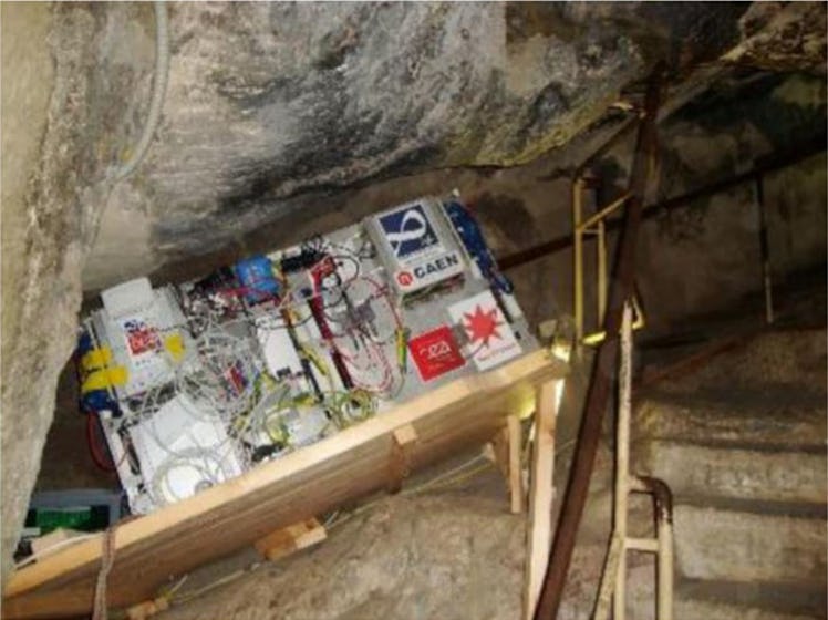color image of a scientific instrument tucked into a dark nook in a rock tunnel