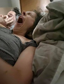 parents in bed, yawning from an unflattering angle