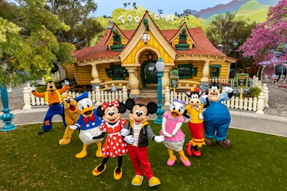 Mickey, Donald Duck, and friends stand in front of the new Toontown.