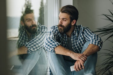 Man staring out window alone