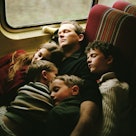 Father and four children sleeping on a train car