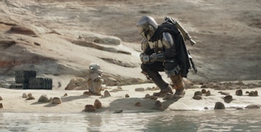 Din Djarin (Pedro Pascal) kneels in front of Grogu in The Mandalorian Season 3 Episode 4