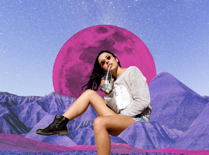 Young woman sipping a drink in front of a pink moon after reading her April 2023 horoscope.