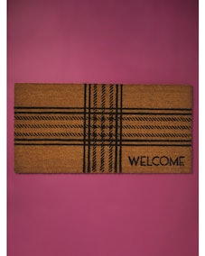 This plaid welcome mat is 'evermore' home decor inspired by the Taylor Swift eras. 