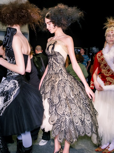 a model wearing a cream tulle evening dress with peacock lace appliqué during Alexander McQueen's fa...