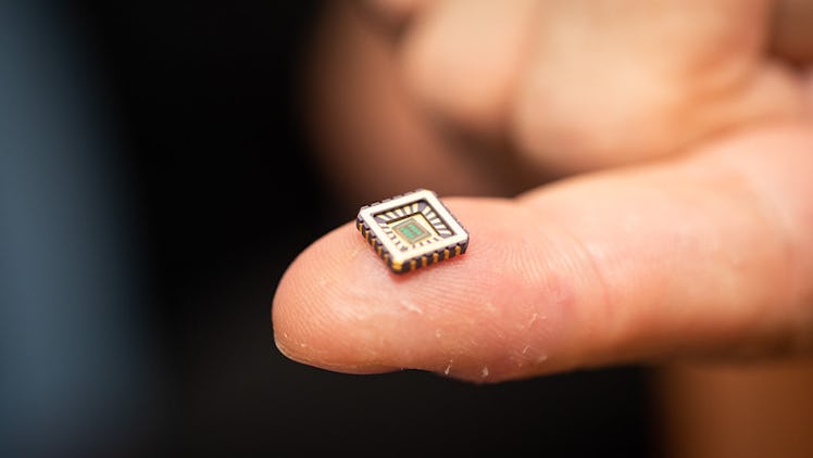 An image of a computer chip on a hand that contains artificial neurons.