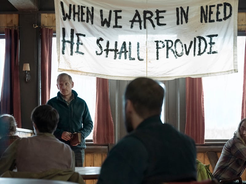 David (Scott Shepherd) stands beneath a religious banner in The Last of Us Episode 8