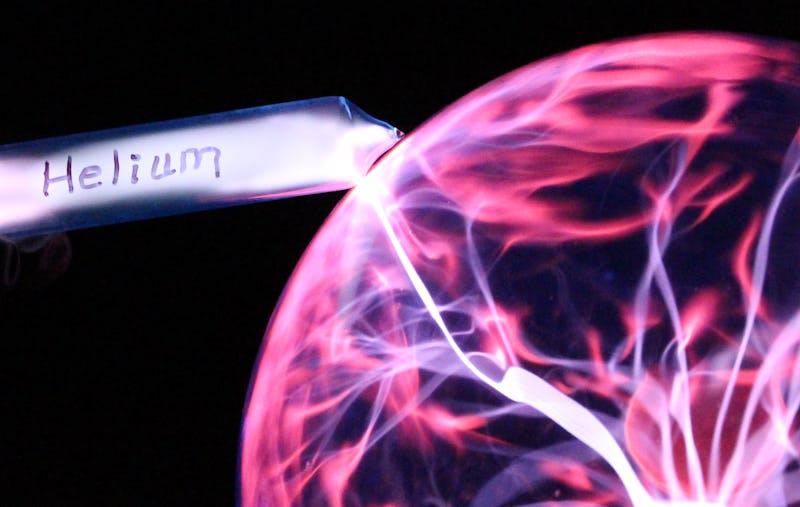 Here a tube of helium is seen glowing in the presence of a plasma ball
