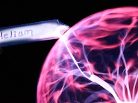 Here a tube of helium is seen glowing in the presence of a plasma ball