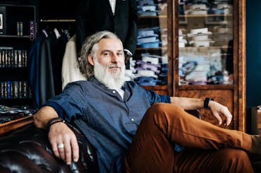 Bearded middle aged man relaxing in men's store.