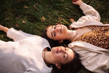 Young friends laying in grass during Saturn in Pisces.