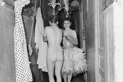 In 1940,  cabaret dancers don their costumes backstage. 