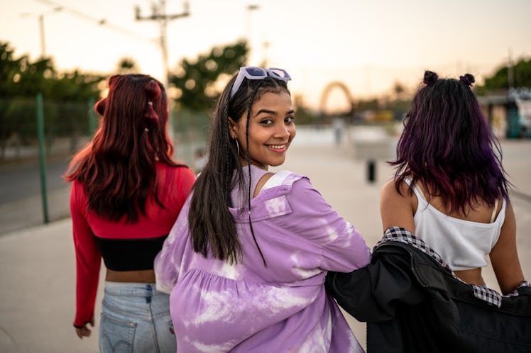 A group of young friends smiling, getting ready to flirt during the April 2023 full Pink Moon, which...