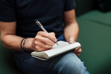 A person sitting down and writing a really good apology letter to someone